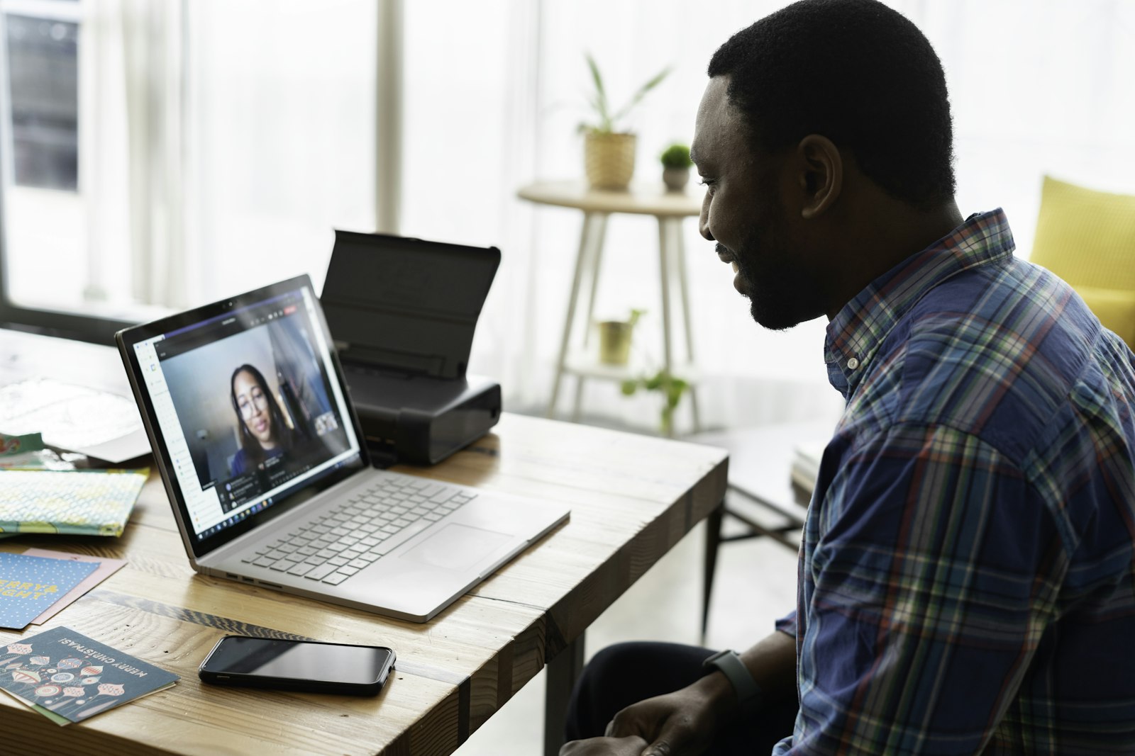 A person smiling on a video call at a laptop.